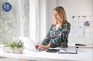 ergo---woman-standing-at-desk-smilng-1